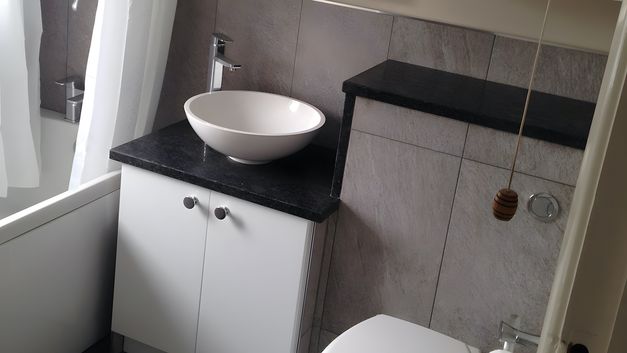 A newly fitting bathroom suite, with tiled boxing around a vanity unit